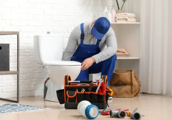 plumber fixing toilet